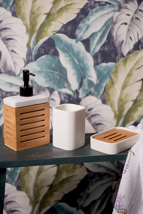 A brown soap dispenser, a white toothbrush holder, and a soap dish