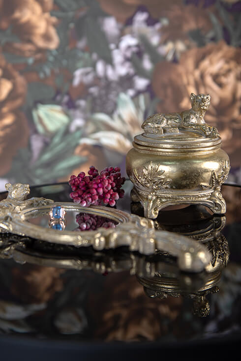 A gold jewelry box with a hand mirror