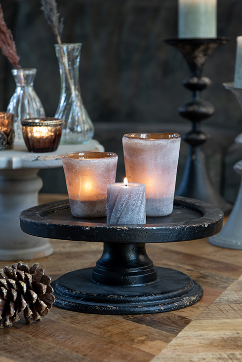 A black cake stand with two candle holders and a candle