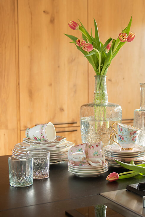 Small plates with teacups and a vase with tulips