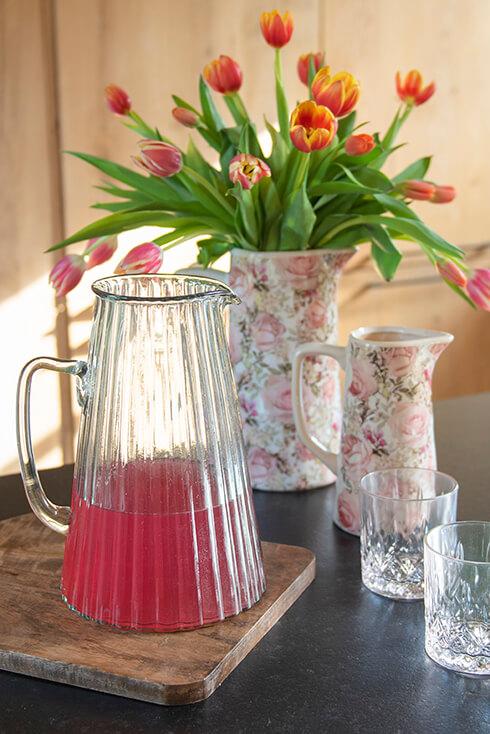 A glass pitcher with fruit punch