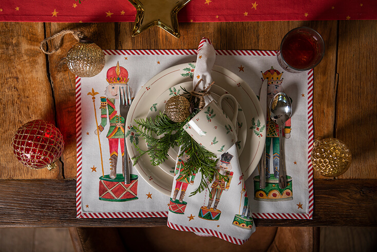 A placemat, dishes, and Christmas ornaments all in a Christmas theme