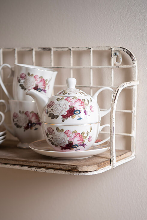 Een witte tea for one set met rode en roze vintage pioenrozen