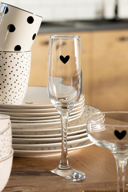 A champagne glass with a black heart