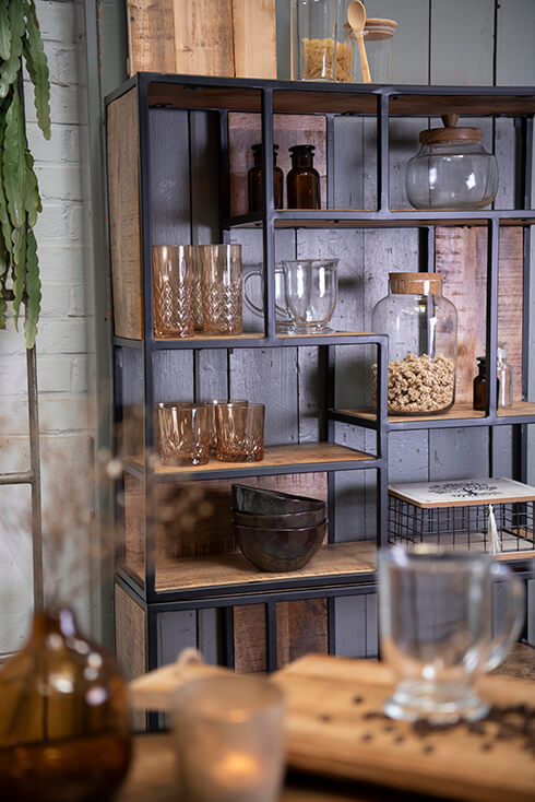 Una libreria industriale con bicchieri da bere, tazze di vetro, ciotole e barattoli di conservazione