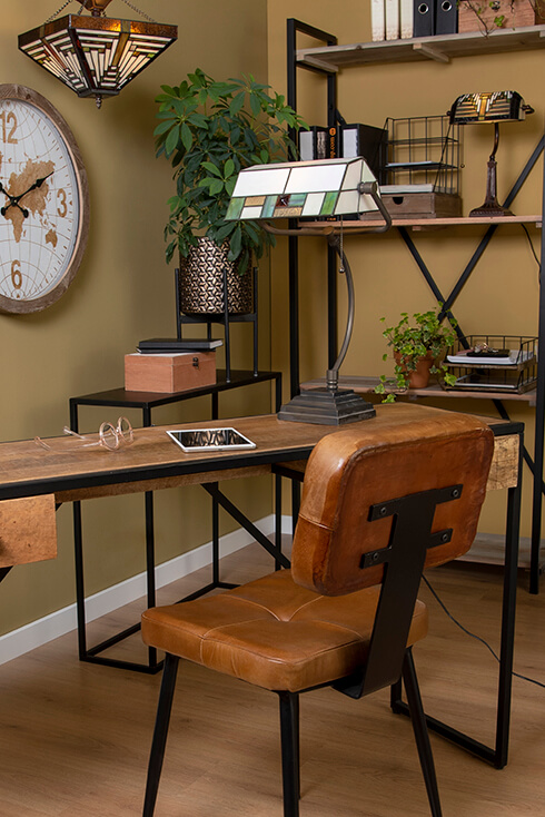 Una scrivania in legno con una lampada da tavolo Tiffany e una sedia da ufficio in pelle