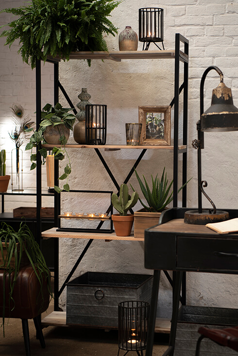 Uno stile d'interni industriale con una mensola contenente vasi, portacandele, cornici per foto e vasi per fiori