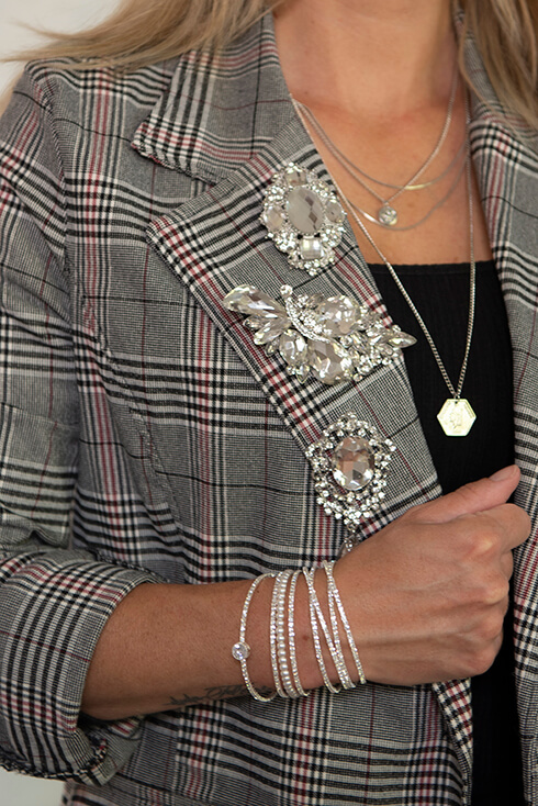 A jacket with three different brooches pinned on it