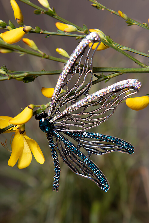 A dragonfly pin with silver and blue wings