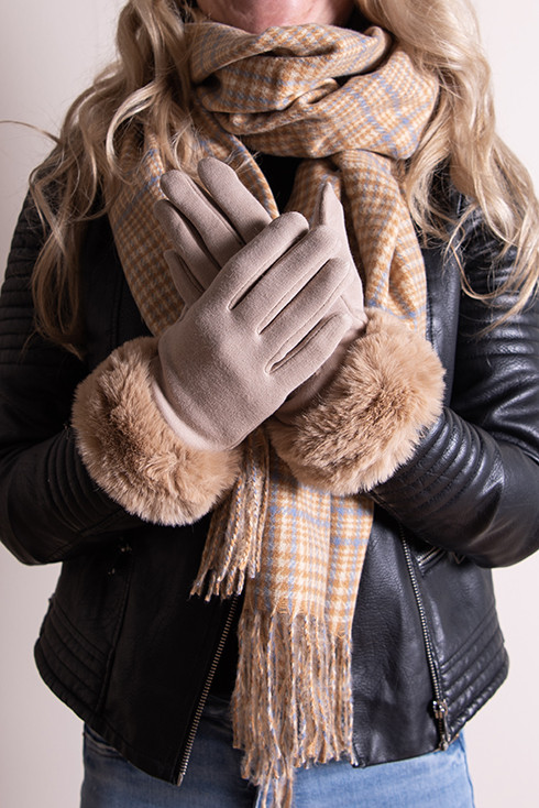 Iemand in een zwarte leren winterjas en een geruite wintersjaal en beige handschoenen draagt