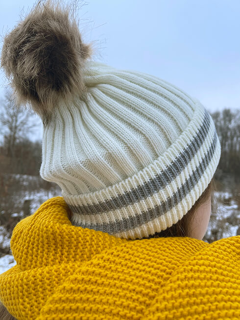 Qualcuno con una sciarpa invernale gialla e un cappello invernale bianco