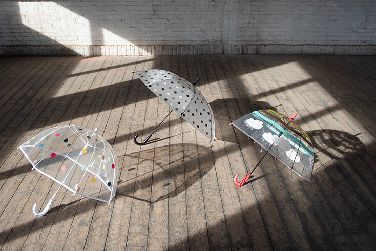 Three transparent umbrellas for children and adults with colorful motifs
