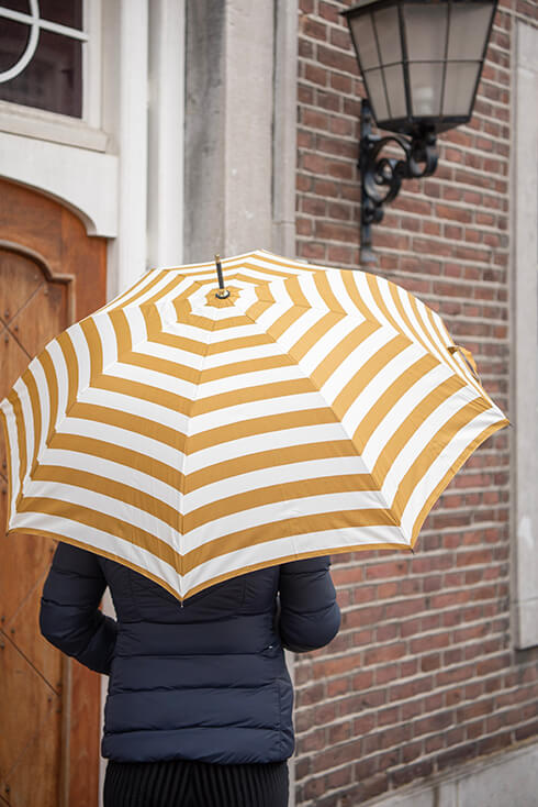 An umbrella with yellow and white horizontal stripes