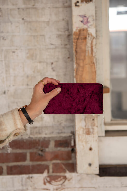 Someone holding a velvet red wallet