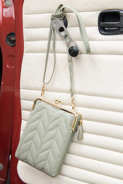 A mint green wallet hanging on the car door