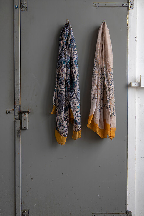 A gray door with two floral lightweight scarves hanging on it