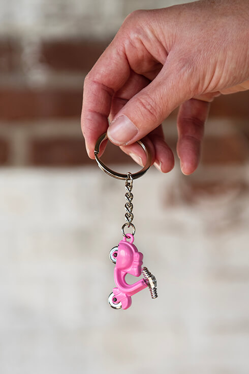 A small keychain of a pink scooter