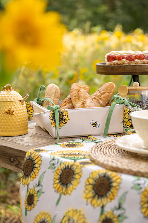 Beige bread basket with sunflowers, filled with small baguettes