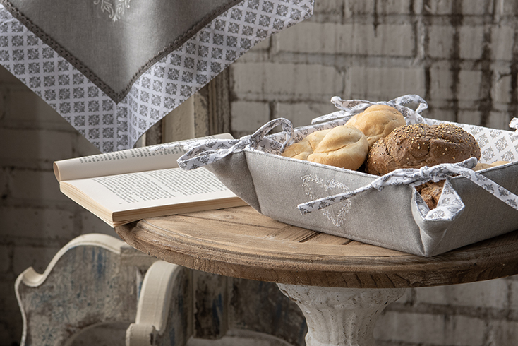 A shabby chic interior with a rustic bread basket filled with rolls