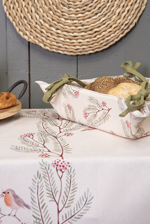 A rural bread basket with branches, berries, and a robin