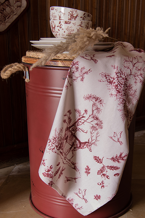 A red barrel with a rustic tea towel featuring an autumn theme