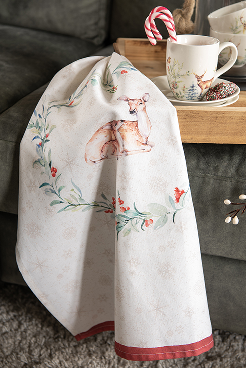 A Christmas kitchen towel with a wreath centered around a deer