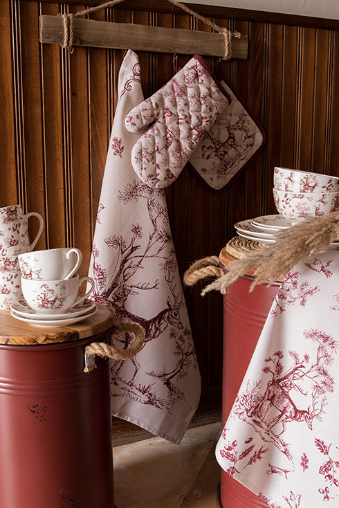 Kitchen textiles with a romantic forest theme including a kitchen towel, oven mitt, pot holder, and tableware