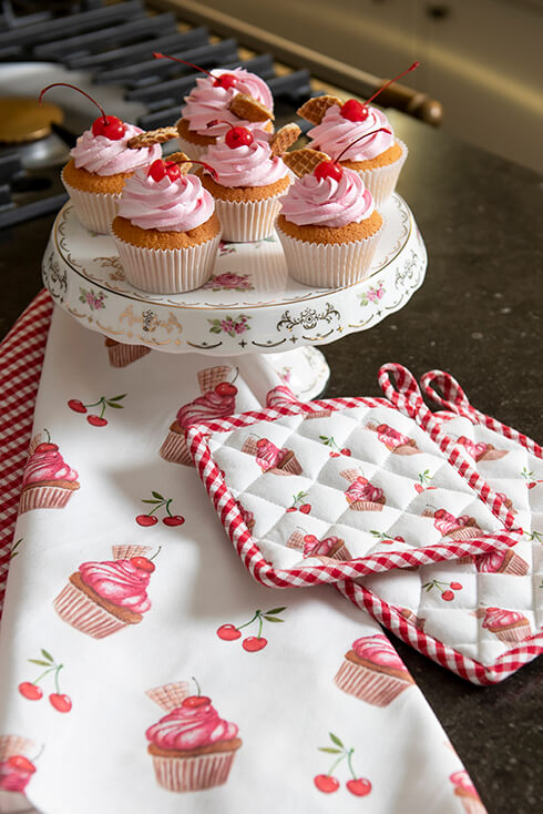 A romantic cake stand with cupcakes and two pot holders with cupcakes
