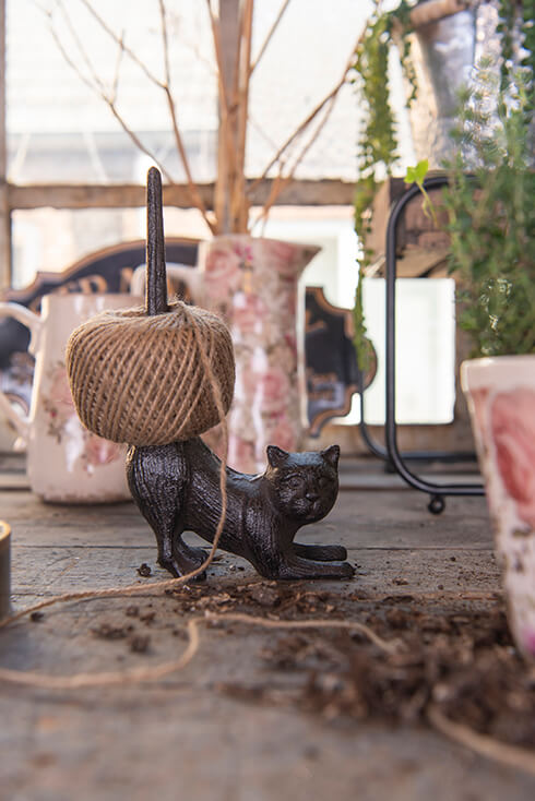 A cast iron cat serving as a string holder