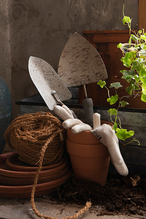 Een terracotta pot met tuingereedschap en handschoenen