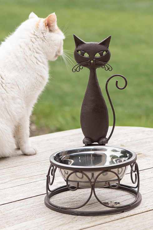 A cat food bowl with an iron cat on top