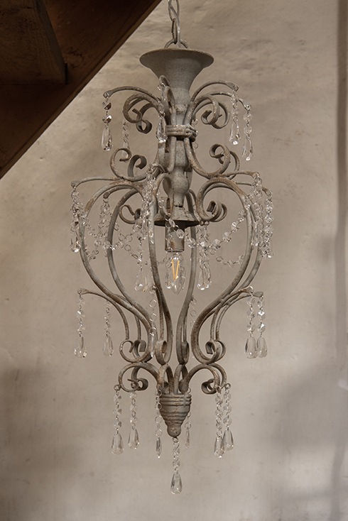 A rural chandelier with metal finishing and glass crystals