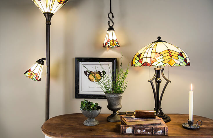 Un salon Tiffany avec une lampe de table, un luminaire suspendu et une lampe sur pied de style similaire