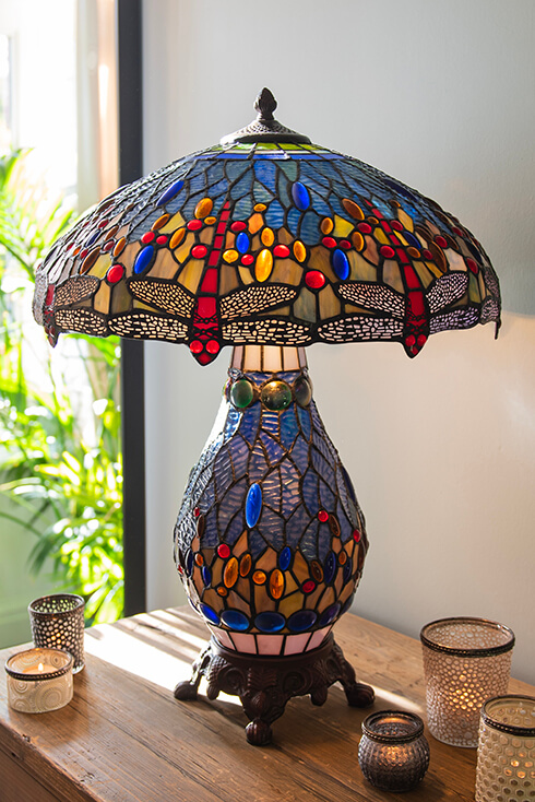 A colorful blue Tiffany table lamp with classic dragonflies
