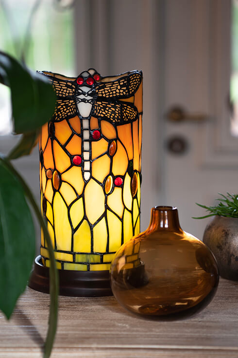 An orange Tiffany table lamp with a dragonfly