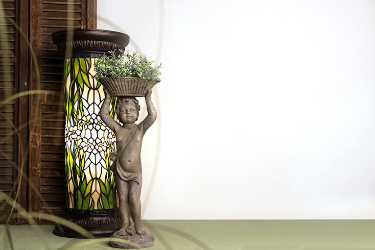A Tiffany column lamp with a figurine in front