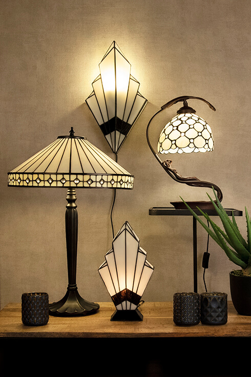 Quattro lampade Tiffany in stile art deco, tra cui tre lampade da tavolo in vetro colorato e una lampada da parete Tiffany