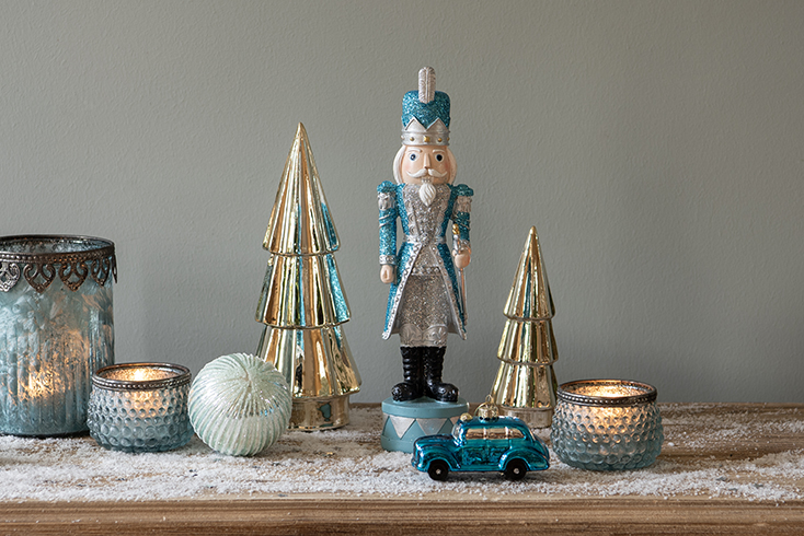 A little car driving among Christmas trees, candles, and a nutcracker