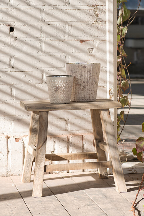 Two flower pots on a wooden stool