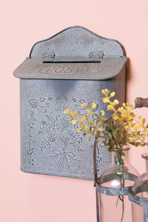 Een romantische ijzeren brievenbus aan een roze muur