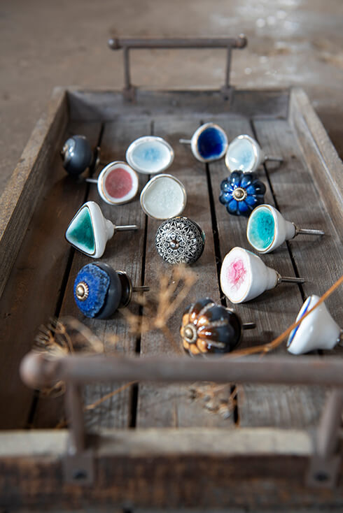 A wooden tray with a collection of cute doorknobs