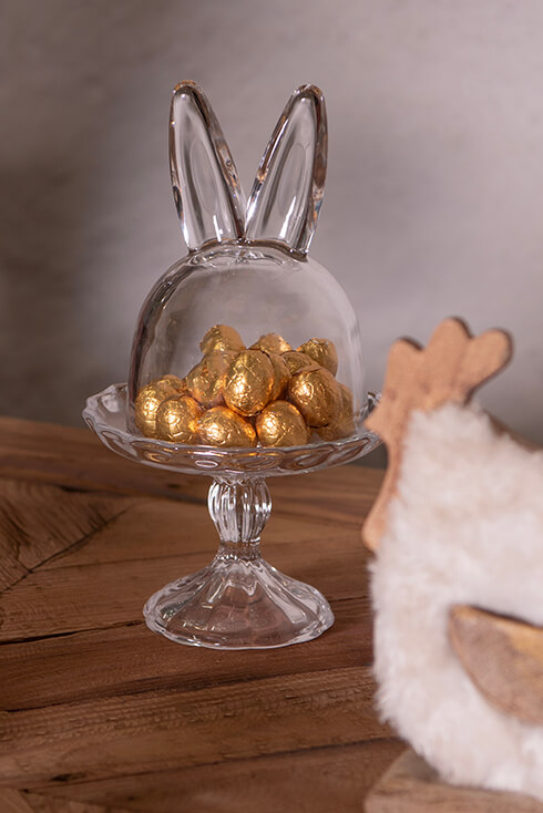 A glass bell jar with chocolate eggs