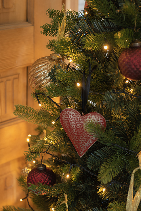 Een hartje en kerstballen aan een kerstboom