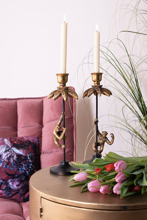 Two modern candle holders with monkeys hanging on them