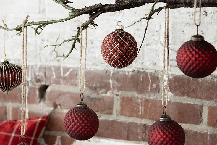 Red Christmas ornaments hanging on a branch