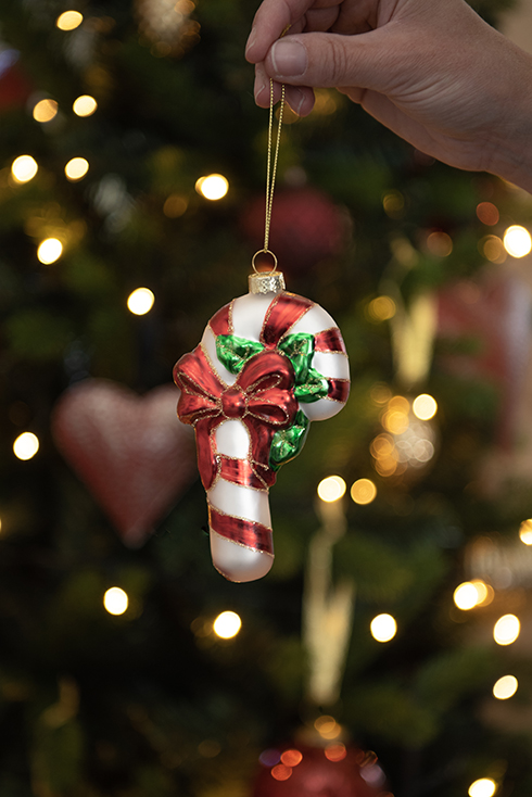 Un ornamento natalizio con un albero di Natale sullo sfondo