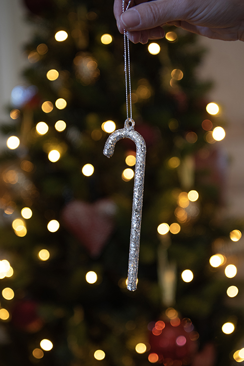 Un ornamento natalizio con un albero di Natale sullo sfondo