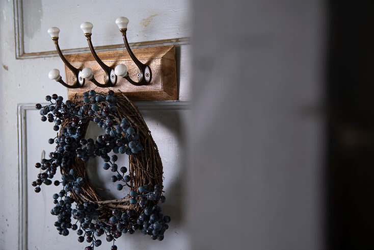 A wreath hanging on a coat rack