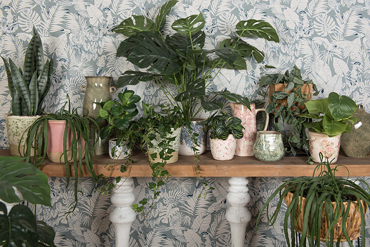 A shelf with flower pots full of artificial plants