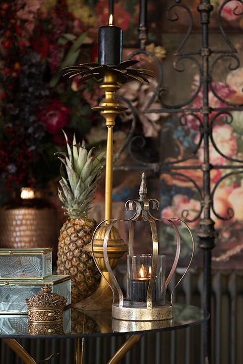 Un interno barocco con una lanterna a forma di corona e dietro di essa c'è un candelabro dorato e due scatole porta gioielli in vetro